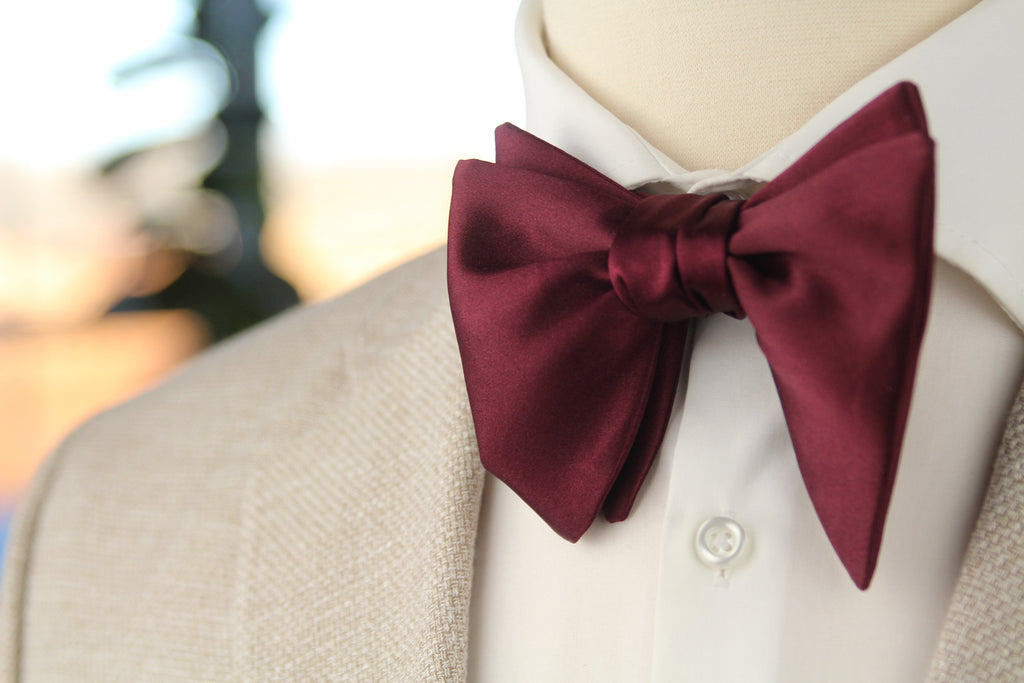 Maroon bow tie worn by a person with a blurred background