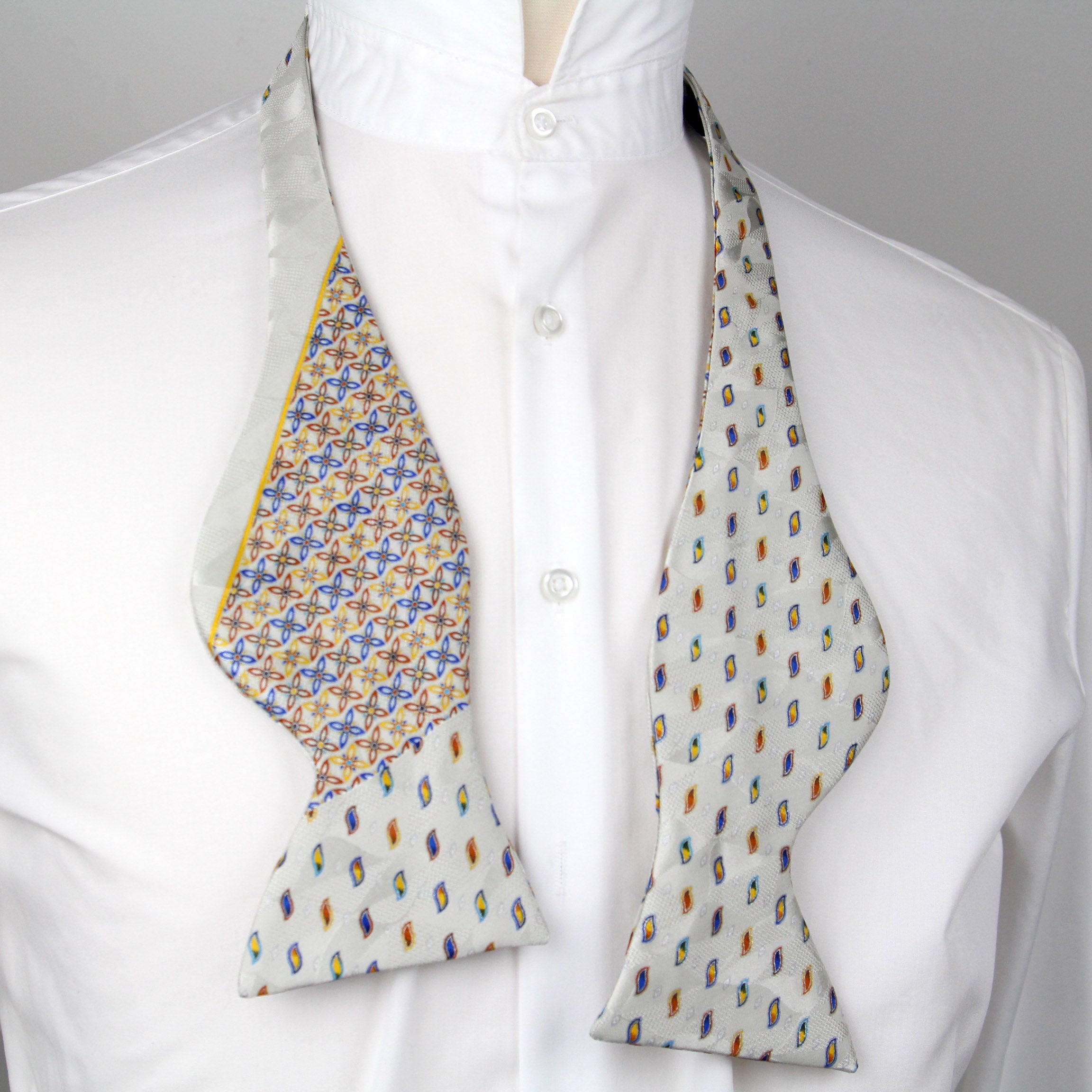 Patterned bow tie on a white shirt with a gray background