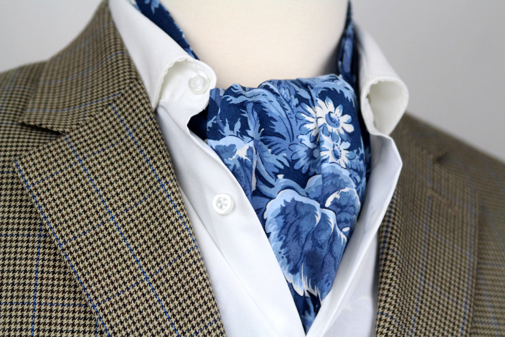 Mannequin wearing a brown checkered blazer, white shirt, and blue floral cravat.