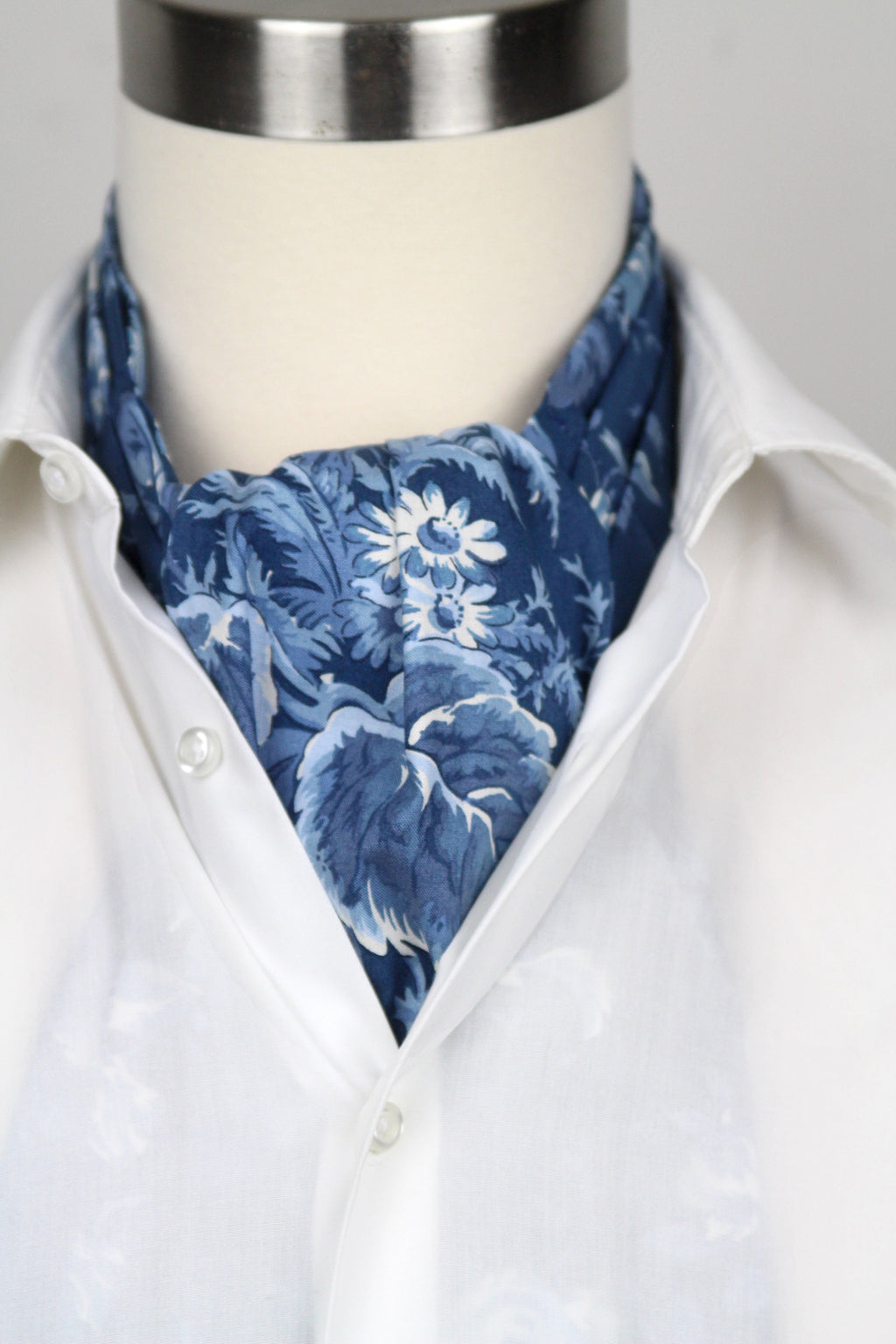 Mannequin wearing a white shirt with a blue floral cravat