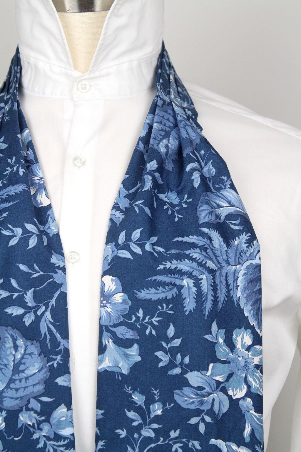 Mannequin wearing a white shirt with a blue floral scarf draped over it