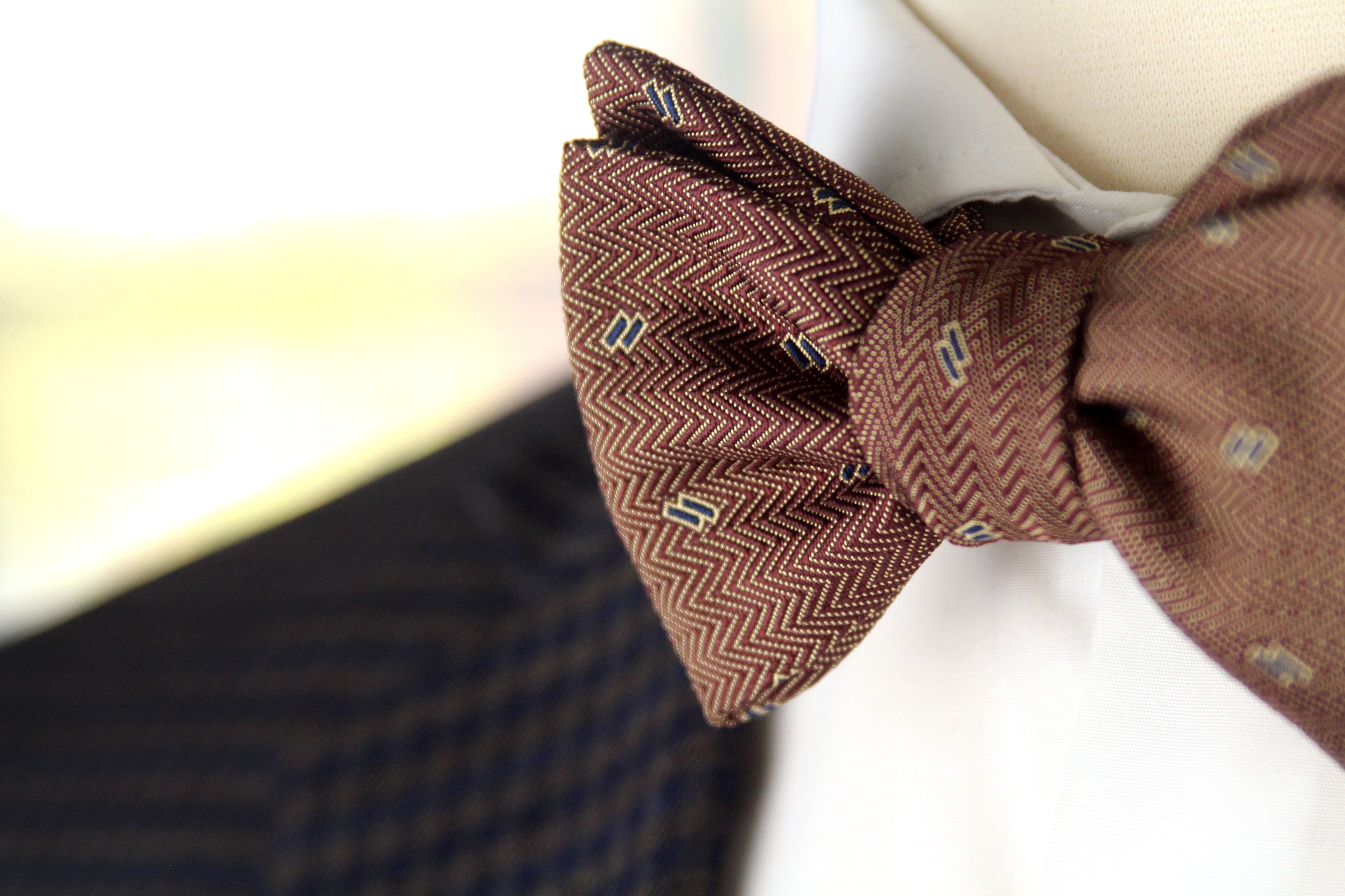 Brown bow tie with a subtle pattern on a blurred background