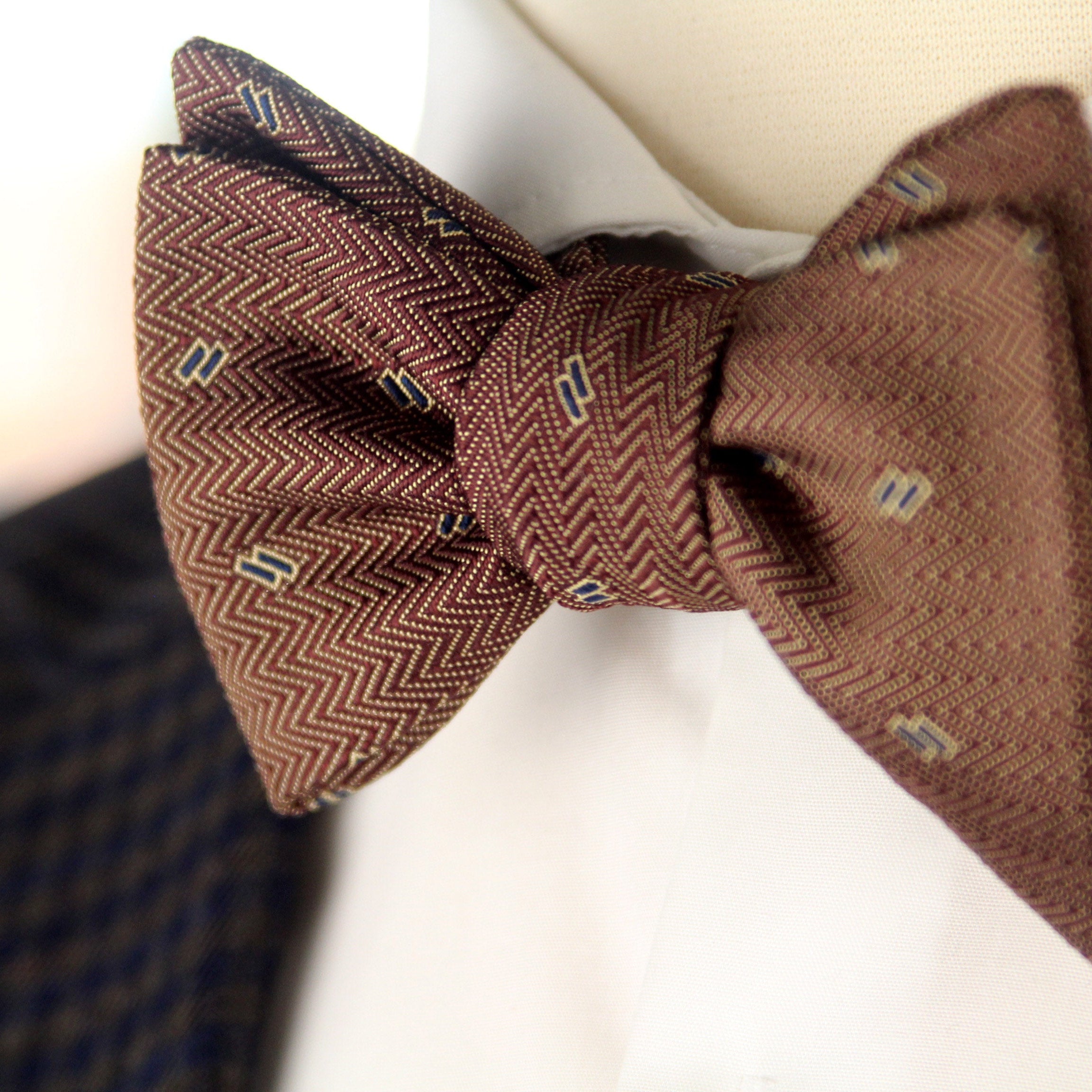Brown herringbone patterned bow tie on a blurred background