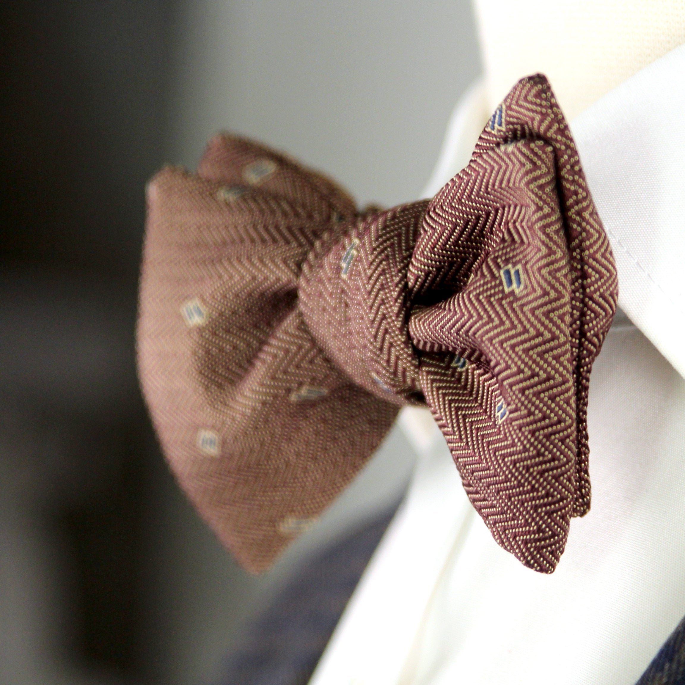 Brown textured bow tie on a mannequin with a blurred background