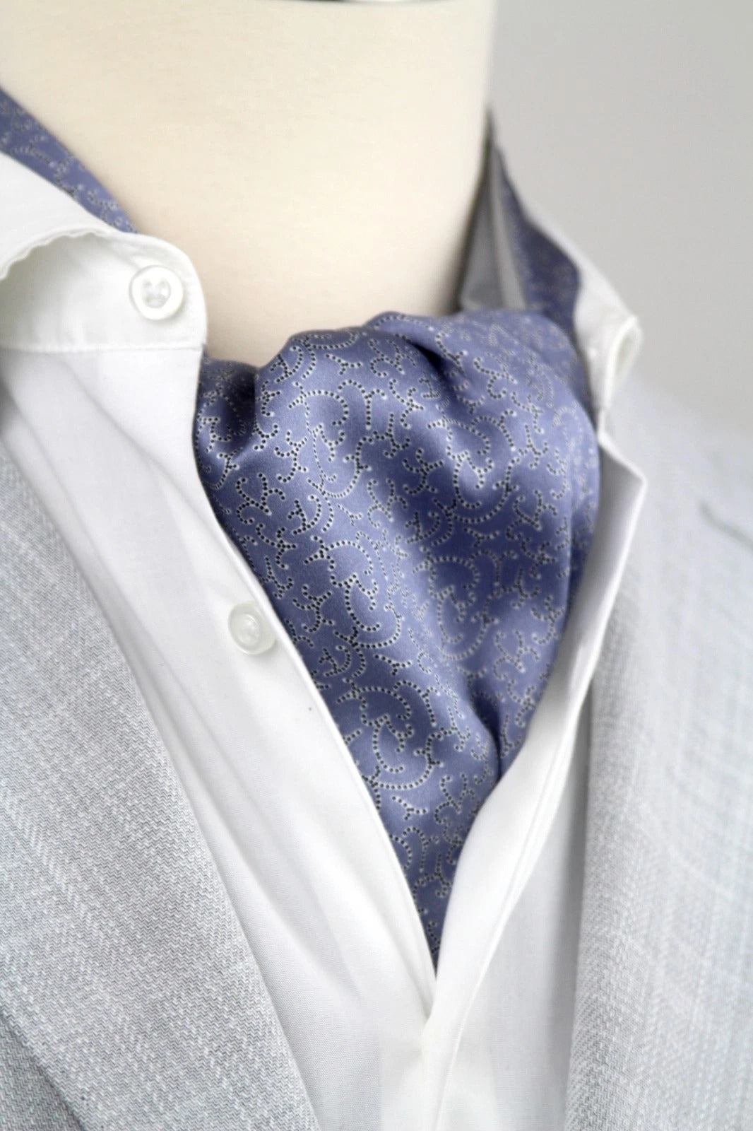 Mannequin wearing a white shirt with a blue patterned cravat