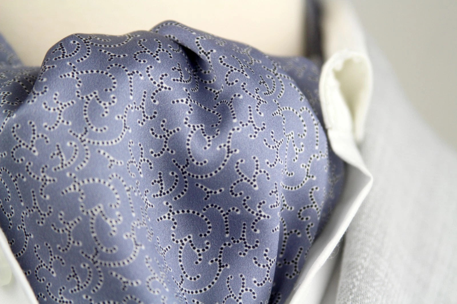 Close-up of a patterned blue tie on a white shirt