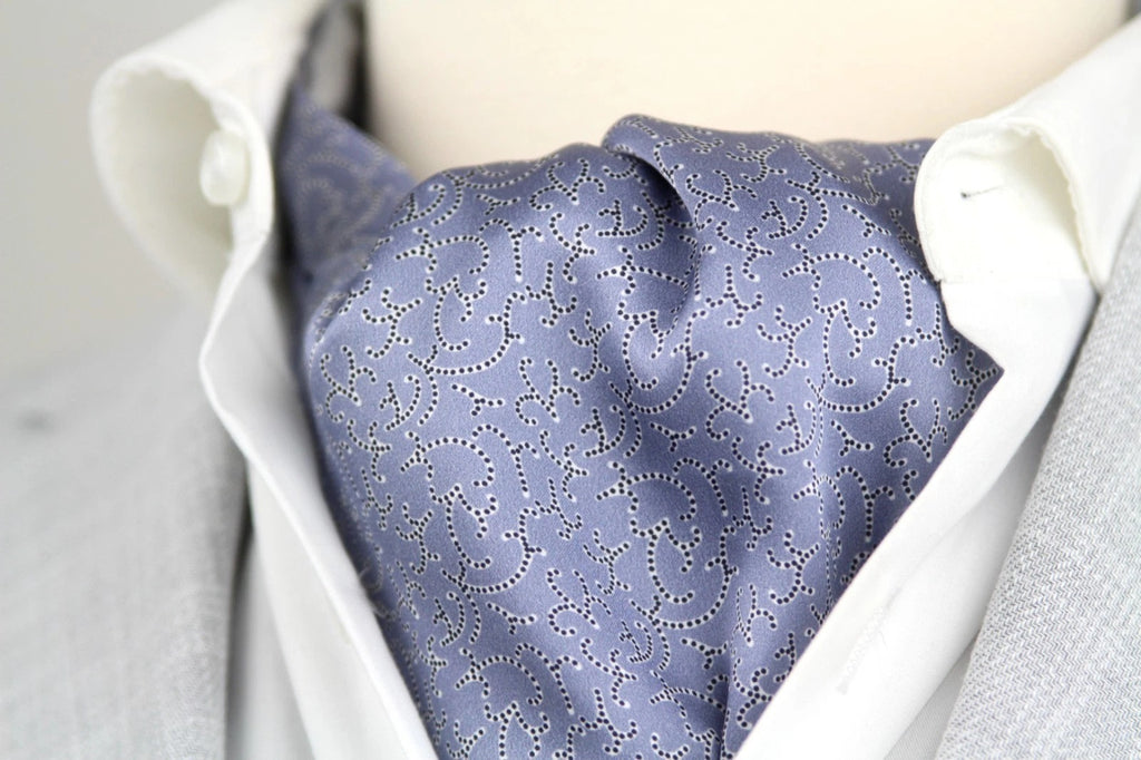 Blue patterned cravat on a white shirt with gray vest