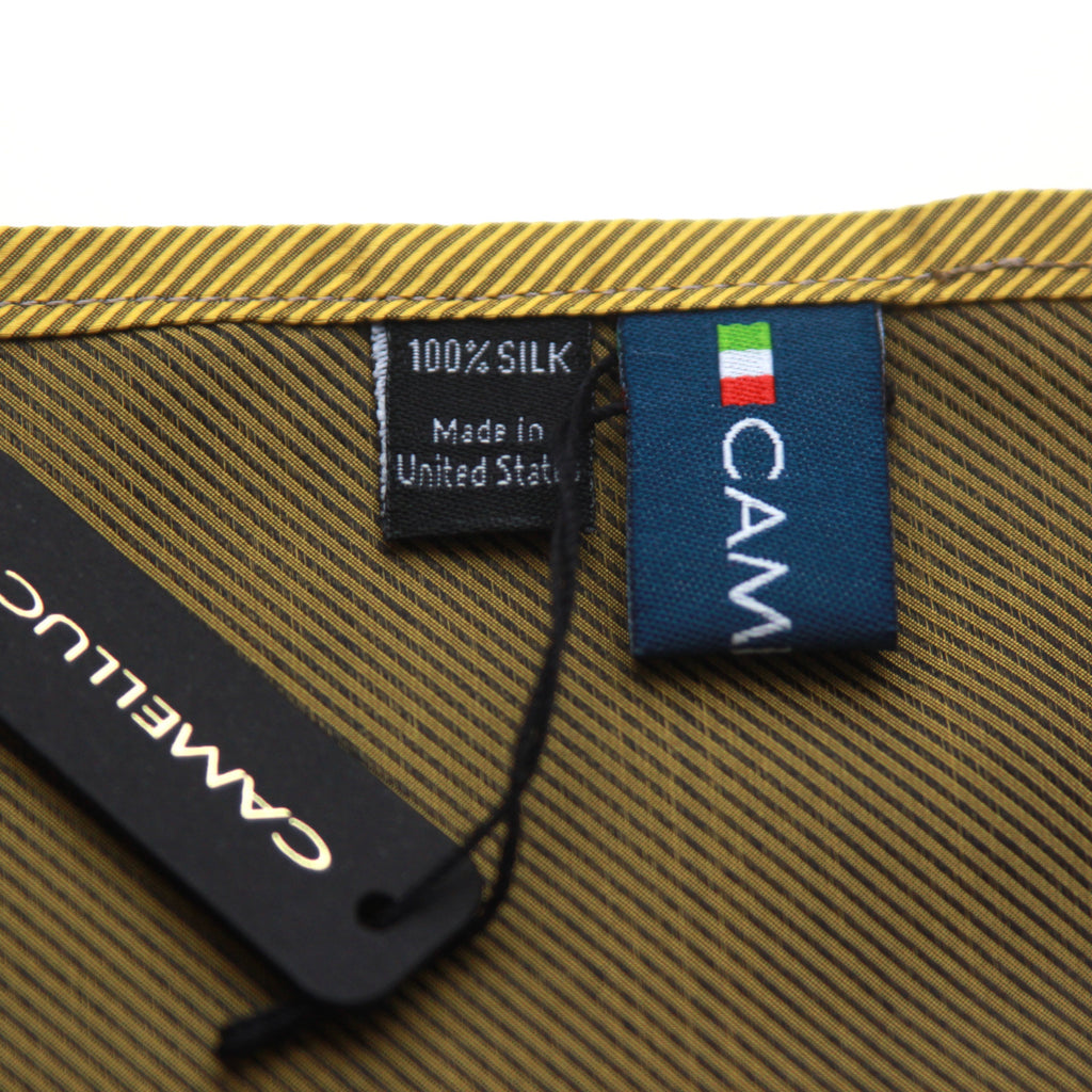 Close-up of a folded silk scarf or fabric accessory with a gold and brown striped pattern, a black hangtag reading CAMELUCCI, and a blue fabric label with the CAM logo and a small Italian flag.