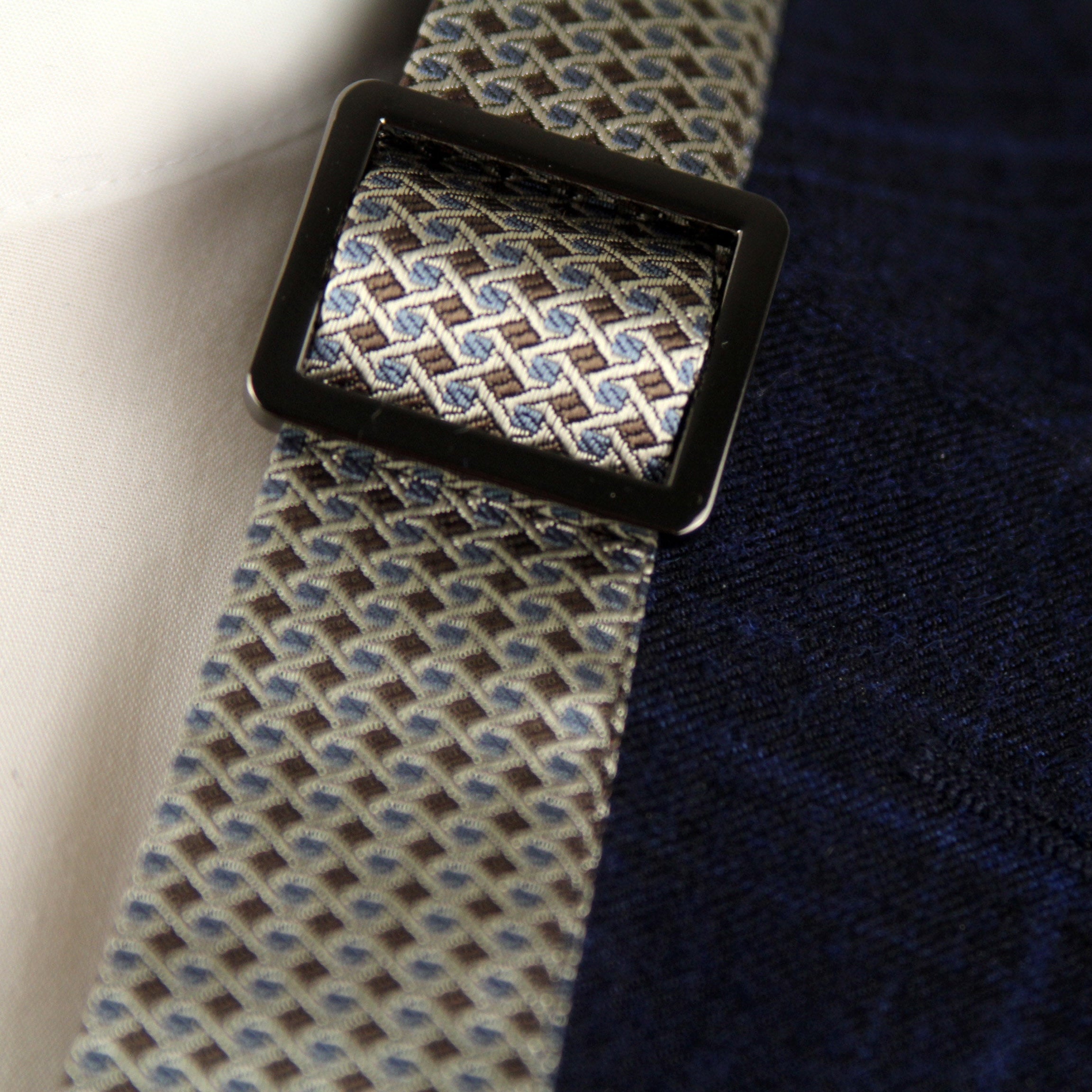 Close-up of a patterned tie with a dark blue jacket
