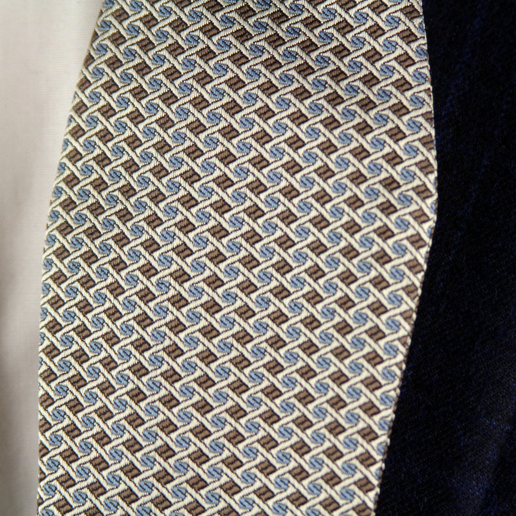 Patterned tie hanging on a dark suit jacket