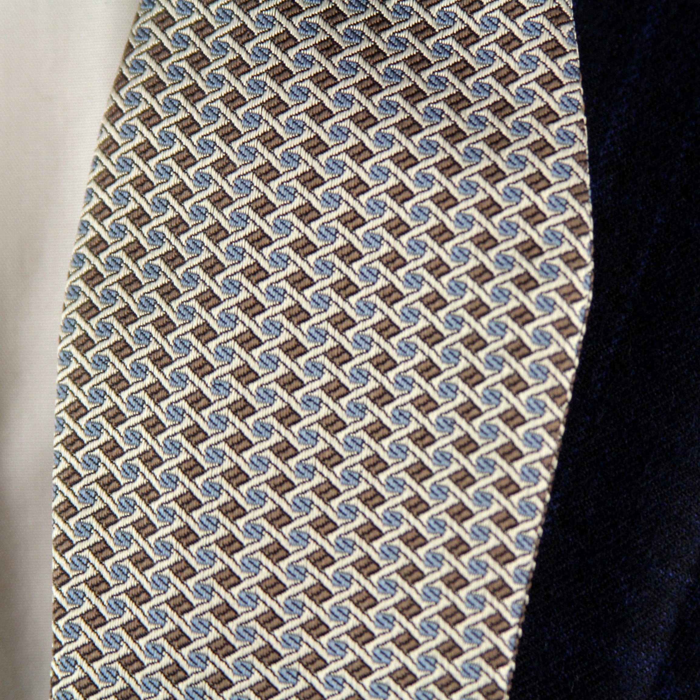 Patterned tie hanging on a dark suit jacket