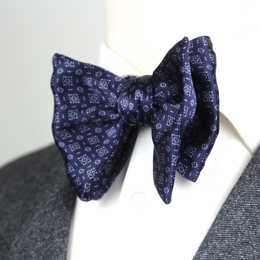 Navy patterned bow tie on a white background