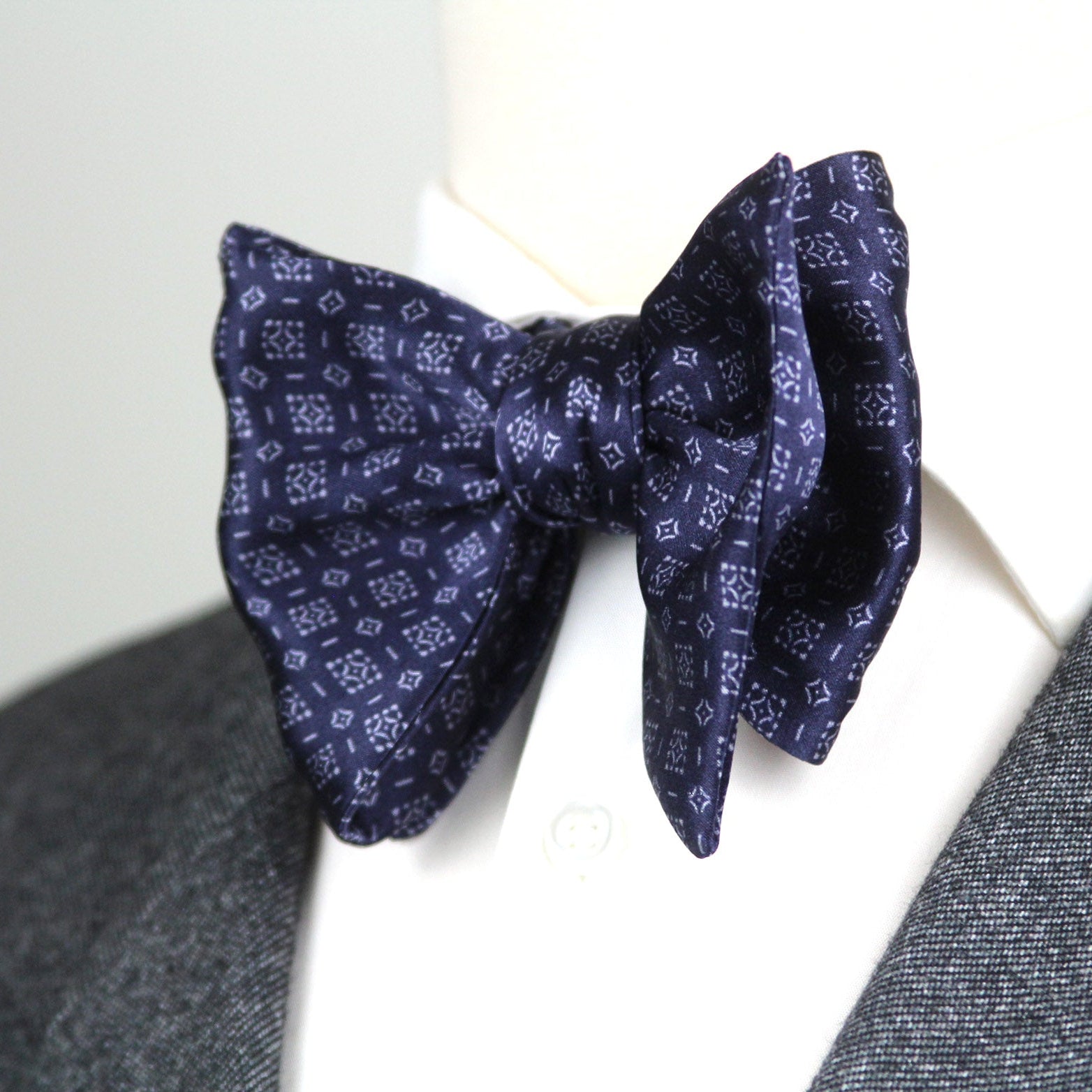 Navy patterned bow tie on a white background