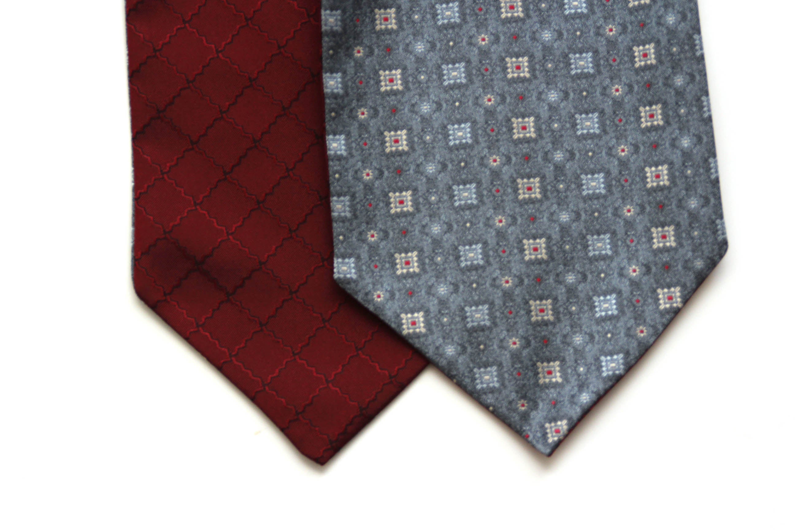 Two patterned ties, one red and one with a geometric design, on a white background.