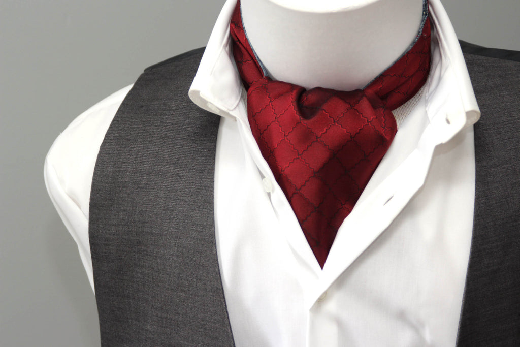 Mannequin wearing a white shirt, gray vest, and red cravat with plaid pattern on a gray background