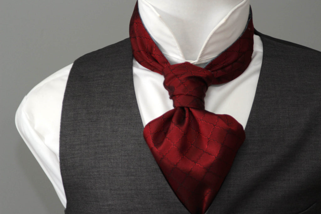 Mannequin wearing a white shirt, gray vest, and red cravat against a gray background