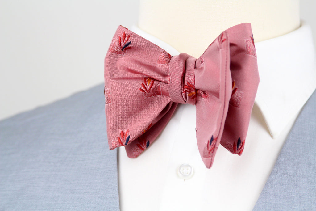 Pink bow tie with floral pattern on a white shirt with blue collar