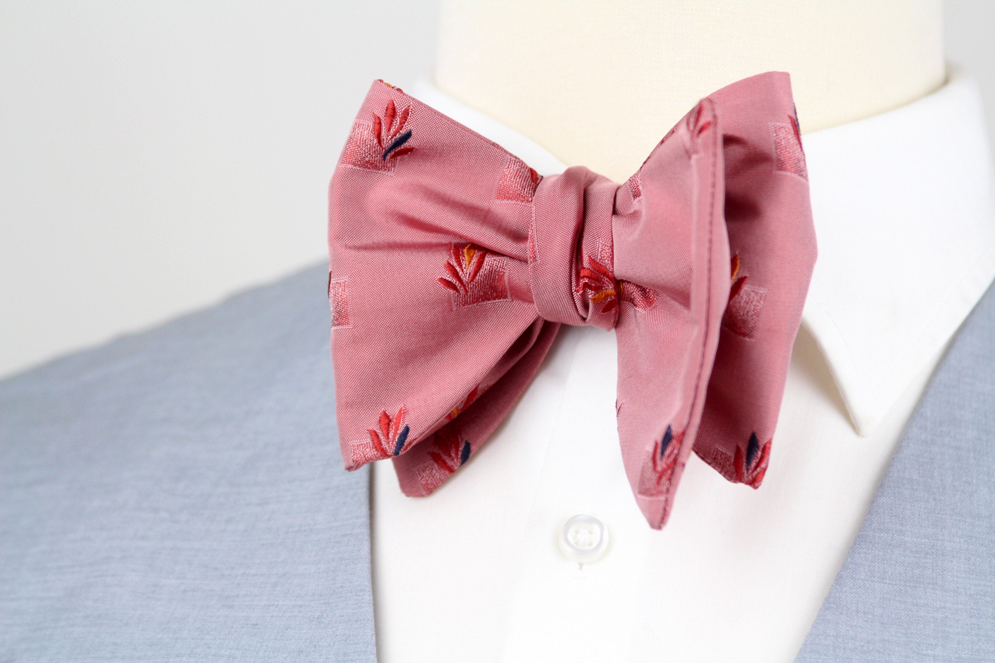 Pink bow tie with floral pattern on a white shirt with blue collar