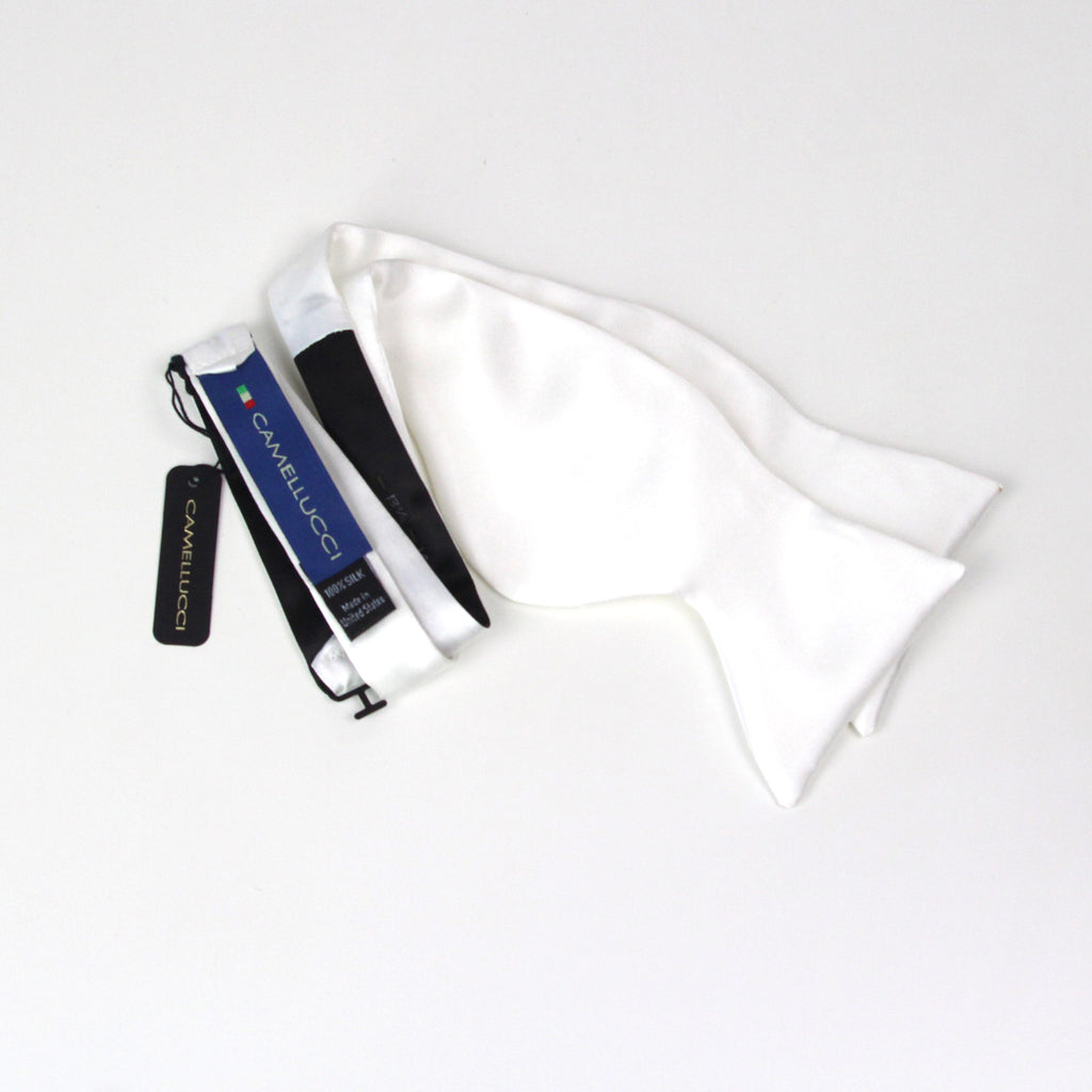 White satin bow tie with black and blue packaging on a light gray background