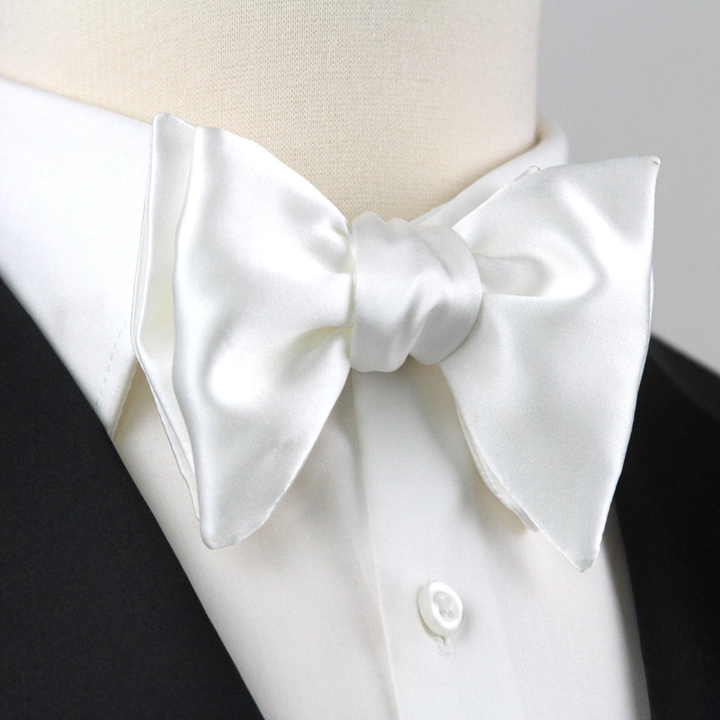 White bow tie on a black suit jacket with a white shirt