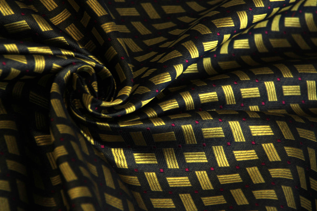 A silk fabric with a black and gold geometric pattern